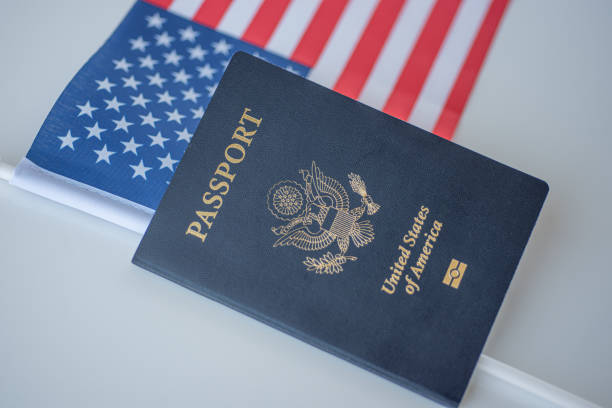 Passport of United states of America next to USA flag on white background.